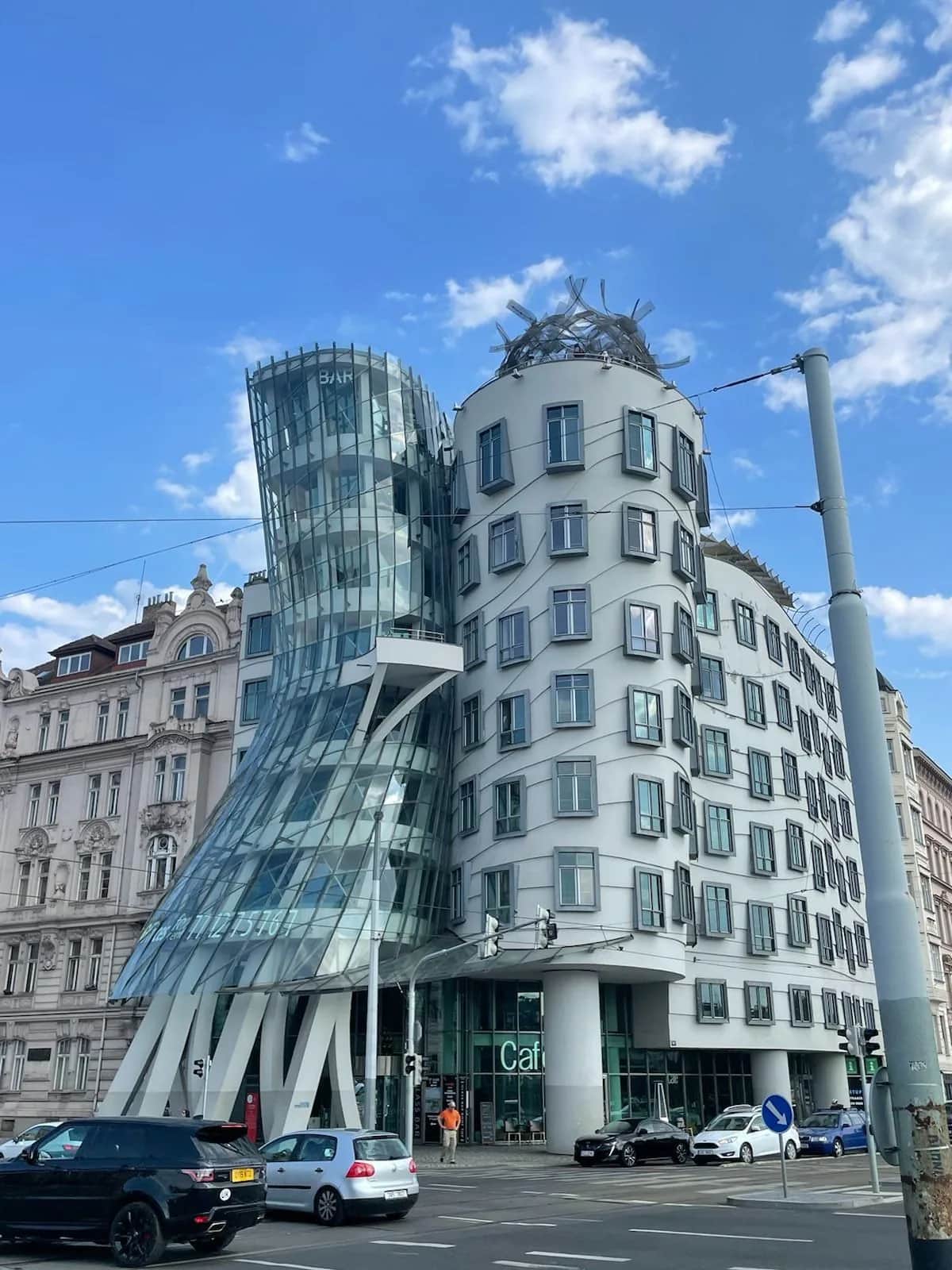 Frank Gehry's Dancing House curving into its glass tower on a street corner, Prague 2023