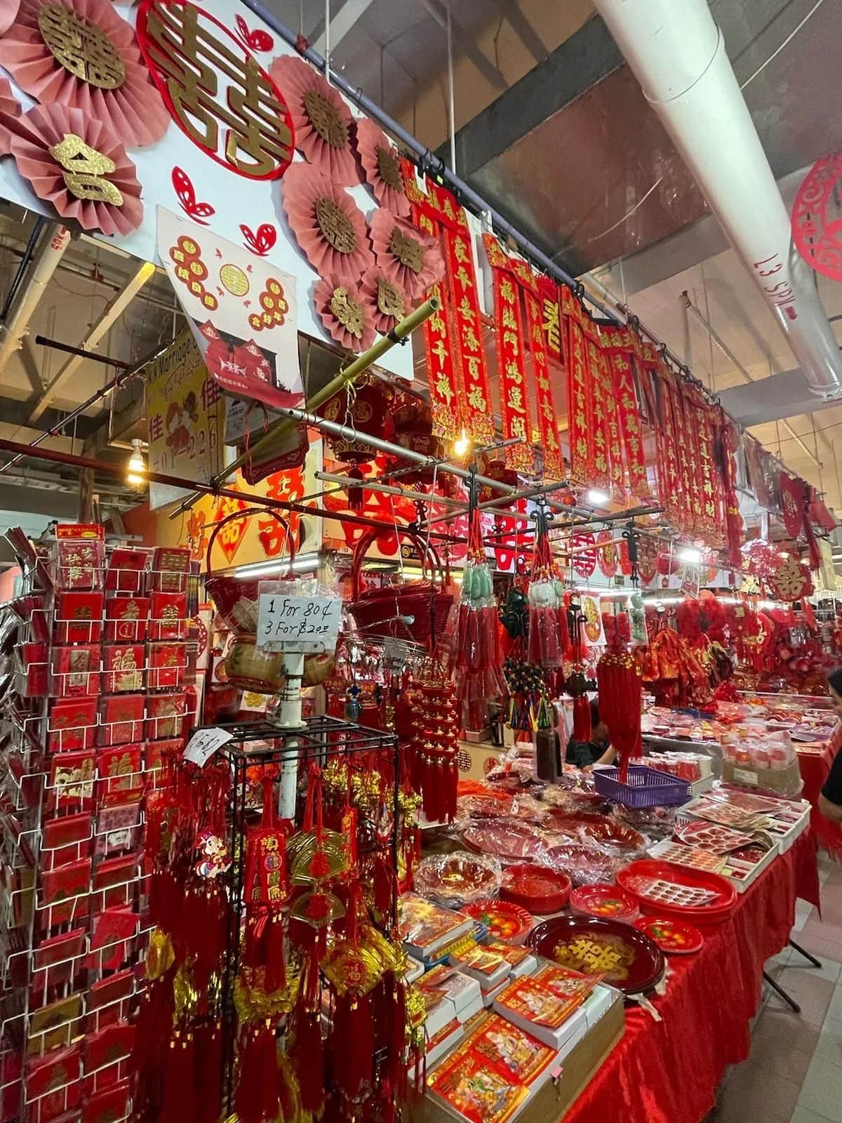 Market stall packed with red and gold new year decorations and paper lanterns, Singapore 2023