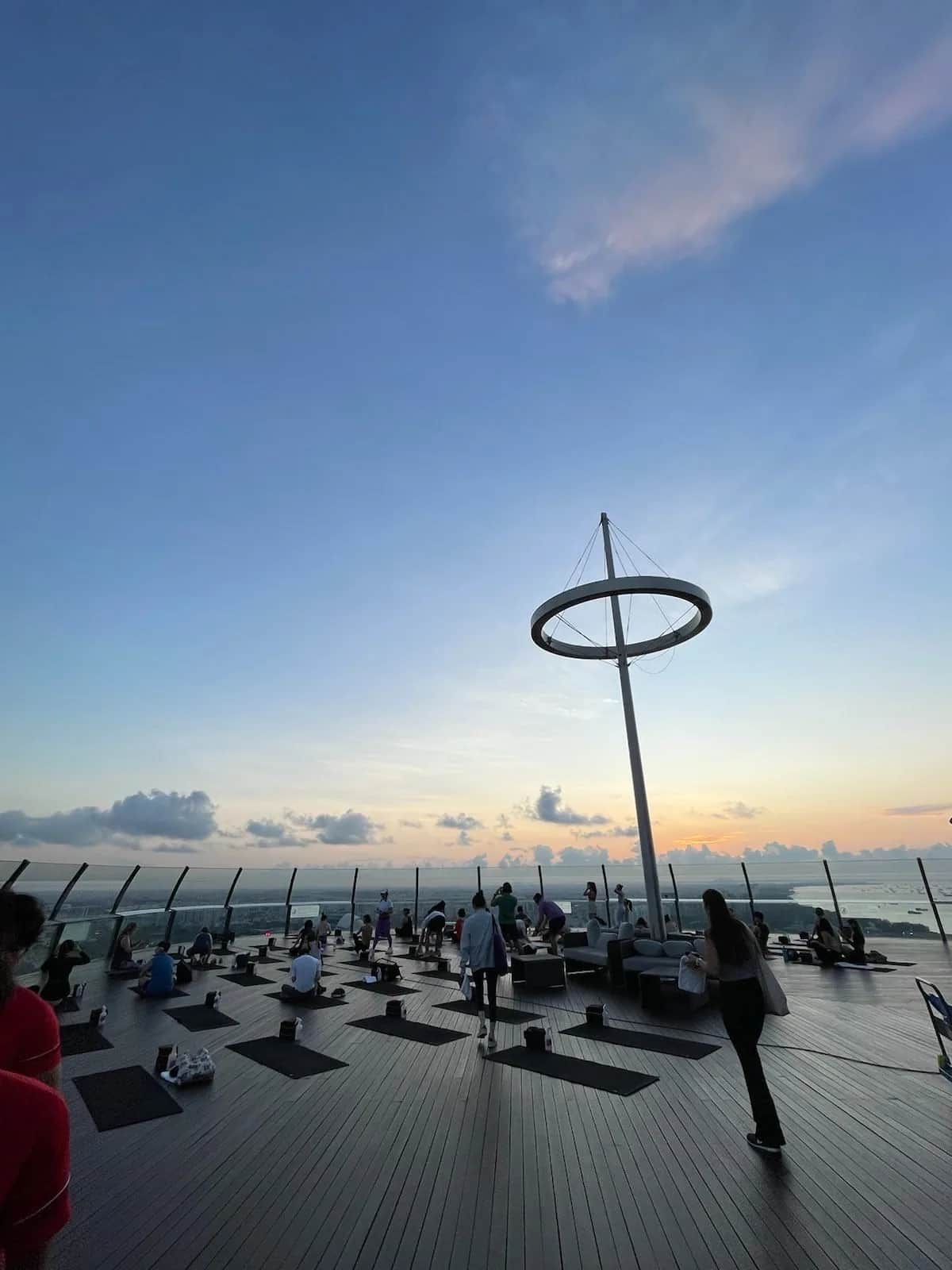 Yoga mats laid across the roof deck at Marina Bay Sands under a low sun, Singapore 2023
