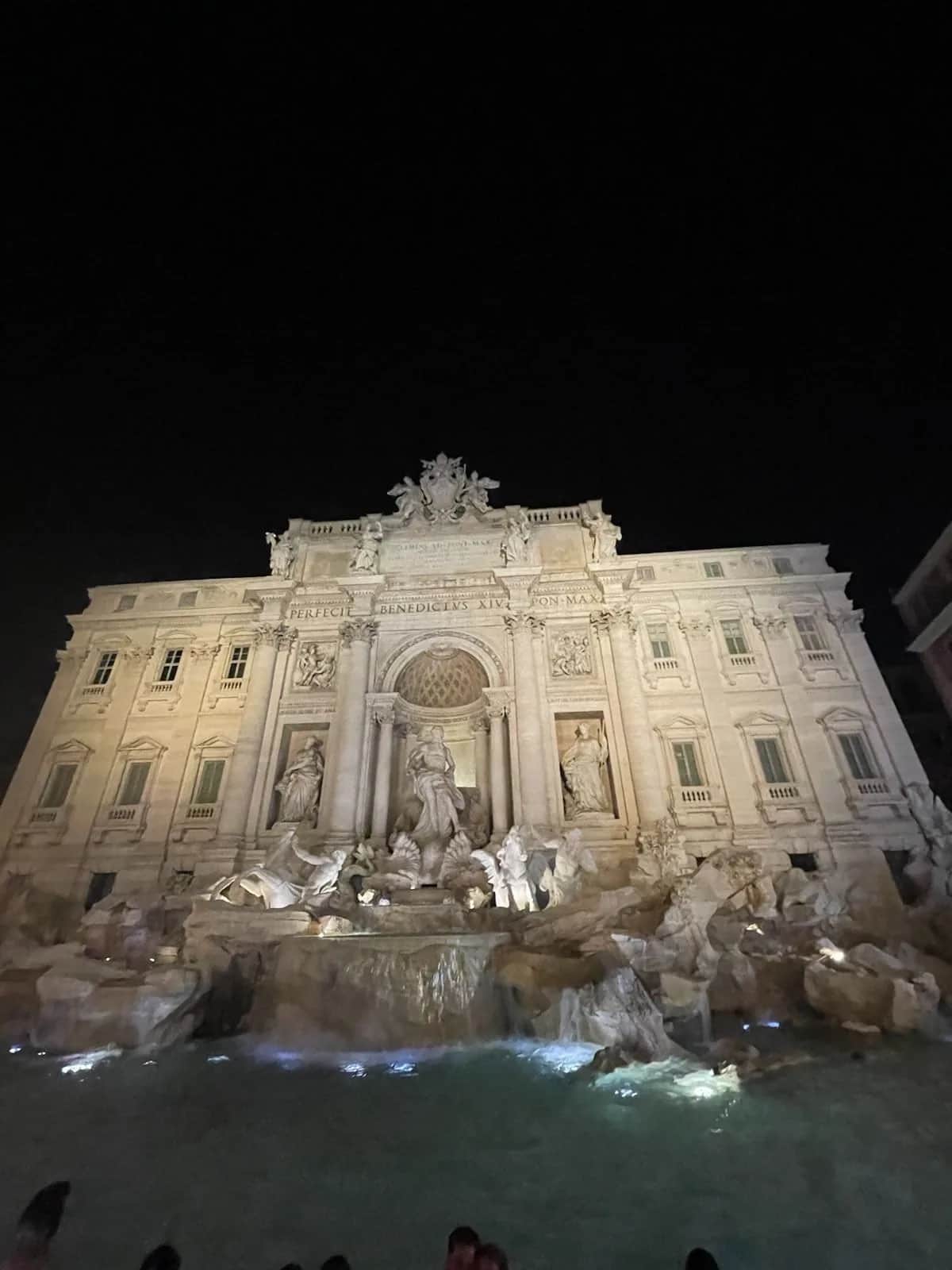 The Trevi fountain lit at night, sea gods and horses above the green water, Rome 2023