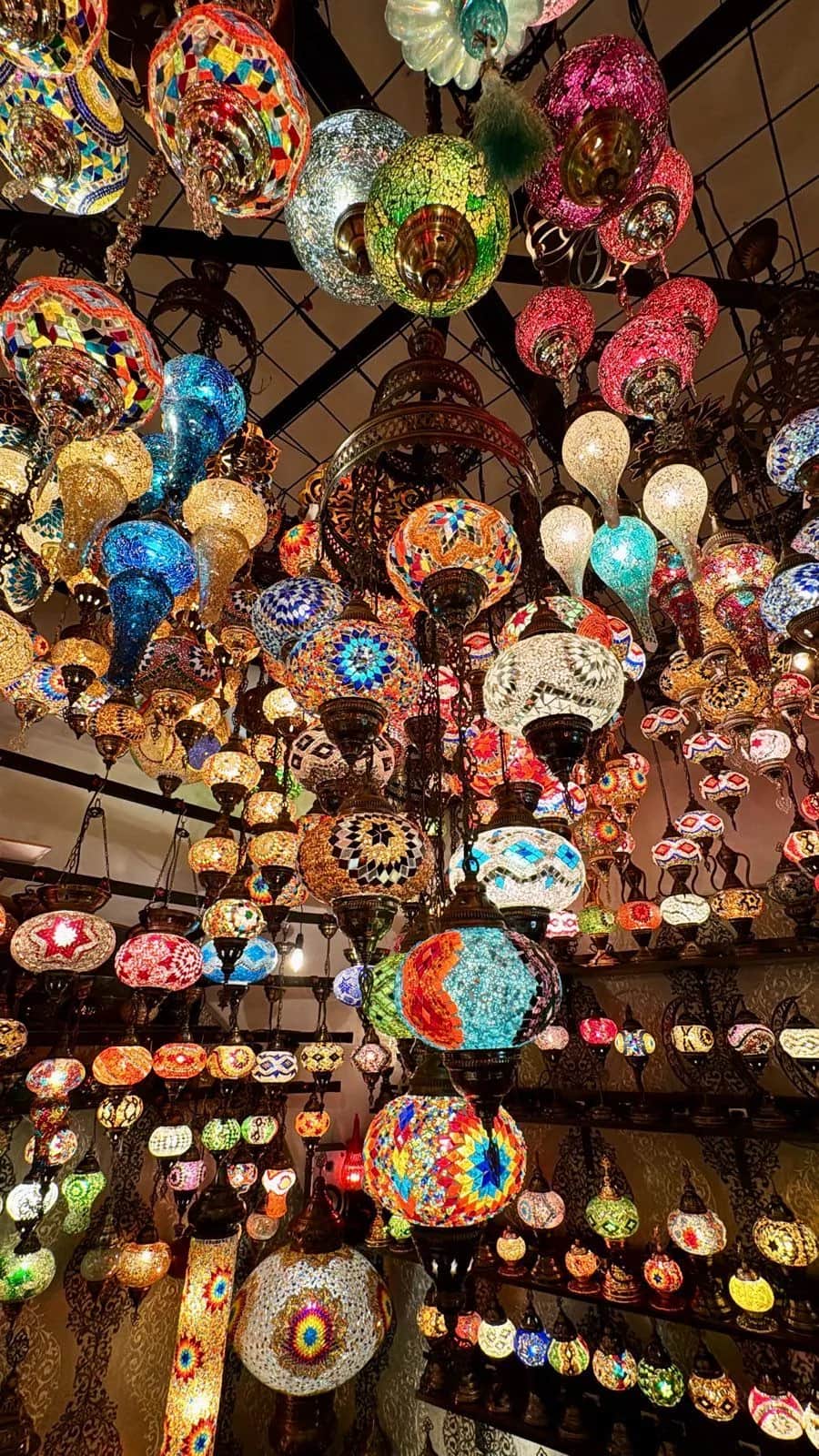 Mosaic glass lamps in every color hanging in dense rows from a shop ceiling, Istanbul 2024