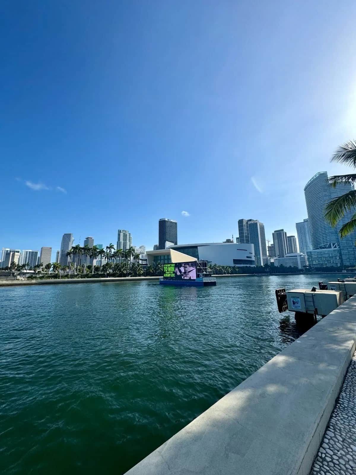 A Nike billboard floating on a barge across the bay from the downtown skyline, Miami 2024