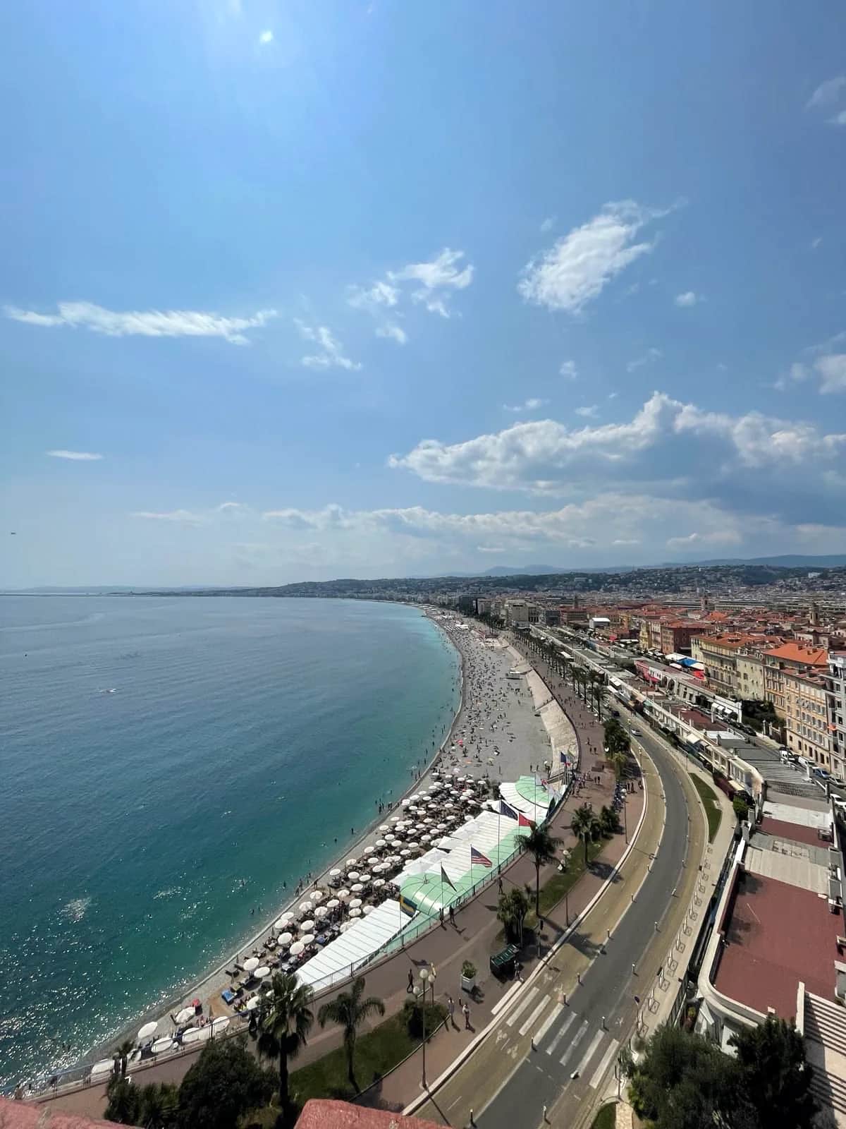 The curve of the pebble beach and waterfront road below the old town, Nice 2023
