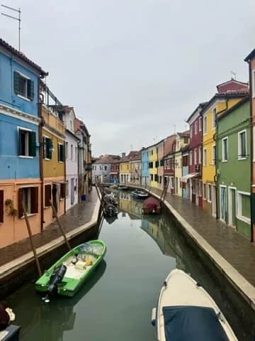 A canal lined with painted houses and moored boats, Burano