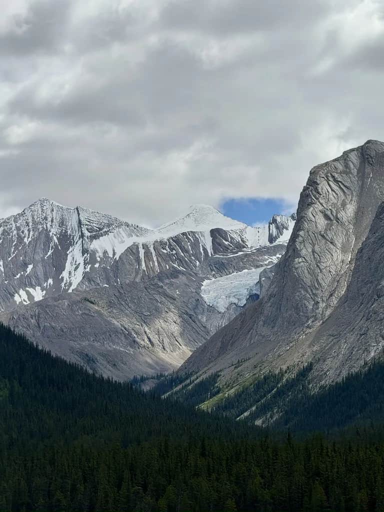 A glacier between high peaks above a spruce valley, Jasper