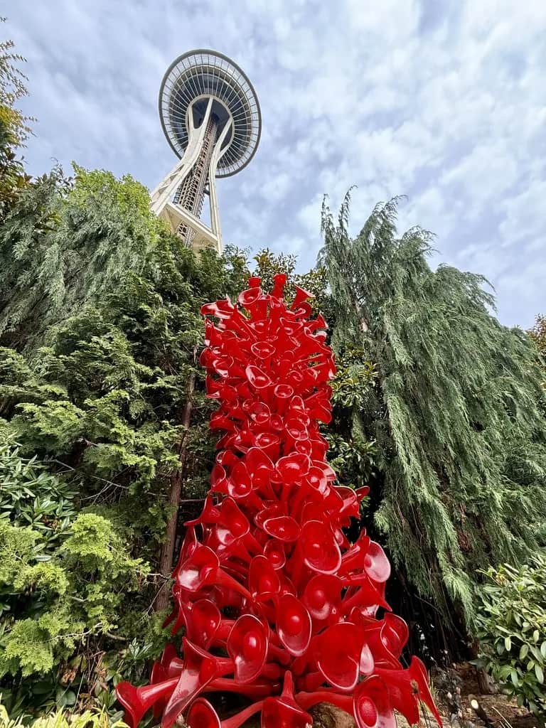 A red blown glass sculpture rising in front of the Space Needle, Seattle
