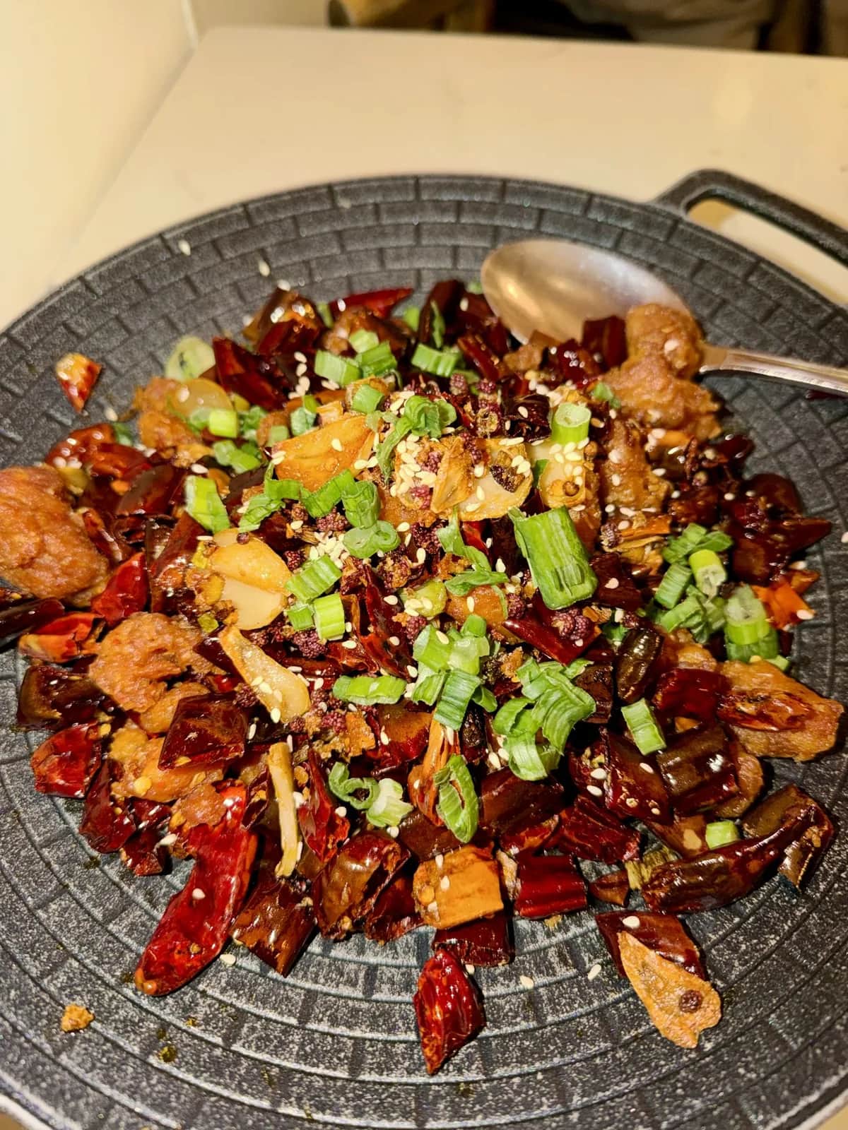 A Sichuan dry pot of dried chiles, garlic and spring onion in a cast iron dish, San Francisco