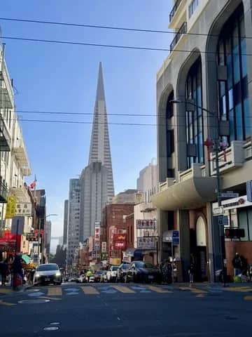 The Transamerica Pyramid framed by Chinatown shop fronts and overhead wires, San Francisco