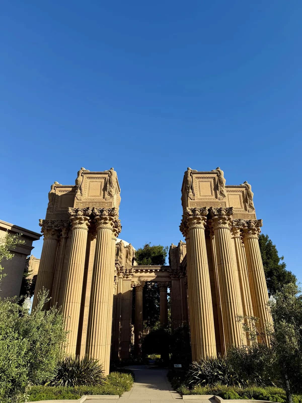 Corinthian columns and their sculpted urns against a cloudless sky, Palace of Fine Arts San Francisco